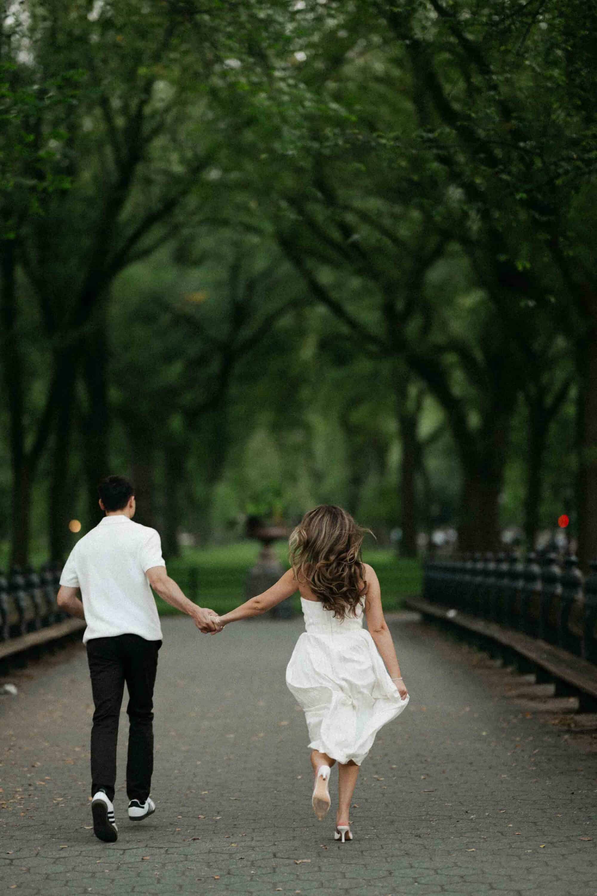 Candid Central Park engagement photos of a couple walking through the park